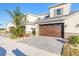 Two-story townhome with a brown garage door and landscaped front yard at 3046 Isles Way, New Smyrna Beach, FL 32168