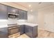 Modern kitchen with gray cabinets, quartz countertops, and stainless steel appliances at 3067 Isles Way, New Smyrna Beach, FL 32168