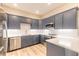 Modern kitchen with gray cabinets, quartz countertops, and stainless steel appliances at 3067 Isles Way, New Smyrna Beach, FL 32168