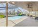 Relaxing screened pool area with patio furniture and ceiling fan at 3103 Royal Palm Dr, Edgewater, FL 32141