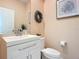 Clean bathroom with white vanity, toilet, and decorative wreath at 3133 Crab Trap Dr, New Smyrna Beach, FL 32168