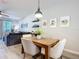 Bright dining area with wooden table and four chairs, adjacent to living room at 3133 Crab Trap Dr, New Smyrna Beach, FL 32168