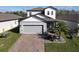 Two-story house with gray siding, gray roof and a brick paver driveway at 3133 Crab Trap Dr, New Smyrna Beach, FL 32168