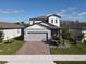 Two-story house with gray siding, gray roof, and a brick paver driveway at 3133 Crab Trap Dr, New Smyrna Beach, FL 32168