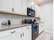 Modern kitchen with white cabinets, black appliances, and subway tile backsplash at 3133 Crab Trap Dr, New Smyrna Beach, FL 32168