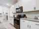 Modern kitchen with white cabinets, black appliances and granite countertops at 3133 Crab Trap Dr, New Smyrna Beach, FL 32168