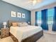 Main bedroom with king bed and blue accent wall at 3133 Crab Trap Dr, New Smyrna Beach, FL 32168