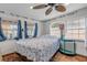 Cozy bedroom with a queen bed, ceiling fan, and ocean-themed decor at 321 Jessamine Ave, New Smyrna Beach, FL 32169