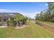 Home's backyard oasis features a screened pool, lush landscaping, and a tranquil canal view at 3309 Modena Way, New Smyrna Beach, FL 32168