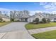 Gray house with three-car garage and nicely landscaped front yard at 3309 Modena Way, New Smyrna Beach, FL 32168