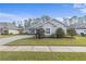 Single-story home with gray exterior, landscaped yard, and paver driveway at 3309 Modena Way, New Smyrna Beach, FL 32168