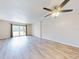 Living room with sliding glass doors, wood-look floors, and ceiling fan at 3800 Saxon Dr # 39039C, New Smyrna Beach, FL 32169