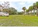 Spacious backyard with lush grass, trees, and a shed at 388 N Glencoe Rd, New Smyrna Beach, FL 32168