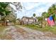 Exterior view of property featuring a quaint fence, front gate, and driveway at 388 N Glencoe Rd, New Smyrna Beach, FL 32168