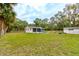 This pink home has a large grassy yard, mature trees, and a wooden fence at 388 N Glencoe Rd, New Smyrna Beach, FL 32168