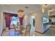 Dining room with glass-top table, chandelier, and view into kitchen and living areas at 417 N Riverside Dr, Edgewater, FL 32132