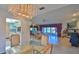 Bright dining room with glass table, chandelier, and views of living room and kitchen at 417 N Riverside Dr, Edgewater, FL 32132