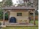 Covered patio with picnic table, grill, and string lights at 4514 Saxon Dr, New Smyrna Beach, FL 32169