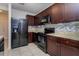 Modern kitchen with dark wood cabinets and black appliances at 4825 Apple Blossom Ln, Saint Cloud, FL 34771