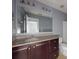 Bathroom with granite countertop, dark wood cabinets, and a large mirror at 526 Mount Olympus Blvd, New Smyrna Beach, FL 32168