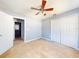 Bedroom with ceiling fan, double-door closet, and view of bathroom at 526 Mount Olympus Blvd, New Smyrna Beach, FL 32168