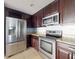 Stainless steel appliances and dark wood cabinets in this kitchen at 526 Mount Olympus Blvd, New Smyrna Beach, FL 32168