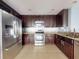 Kitchen with stainless steel appliances and dark wood cabinets at 526 Mount Olympus Blvd, New Smyrna Beach, FL 32168