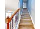 Elegant staircase with wood railing and carpet runner at 526 Mount Olympus Blvd, New Smyrna Beach, FL 32168