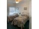 Guest bedroom with two twin beds and ceiling fan at 5300 S Atlantic Ave # 16201, New Smyrna Beach, FL 32169