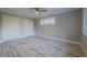 Spacious bedroom with wood-look floors, double closets, and a ceiling fan at 555 Wildwood Dr, New Smyrna Beach, FL 32168