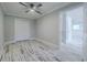 Bright bedroom with wood-look floors and double doors leading to a closet at 555 Wildwood Dr, New Smyrna Beach, FL 32168