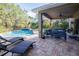 Relaxing covered patio with pool, lounge chairs, and seating area at 6932 Vintage Ln, Port Orange, FL 32128