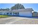 Light blue house with a white garage door and a well-maintained lawn at 752 Tarry Town Trl, Port Orange, FL 32127