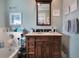 Bathroom features a dark wood vanity, neutral tile, and a large mirror at 803 Silk Oak Ct, New Smyrna Beach, FL 32168