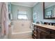 Bathroom with a bathtub, dark wood vanity, and light teal walls at 803 Silk Oak Ct, New Smyrna Beach, FL 32168