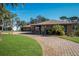 Brick ranch house with paver driveway and palm trees at 803 Silk Oak Ct, New Smyrna Beach, FL 32168