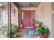 Covered porch with red door, bench, and potted plants at 803 Silk Oak Ct, New Smyrna Beach, FL 32168