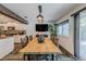 Open concept dining area with large wooden table and modern lighting at 814 E 20Th Ave, New Smyrna Beach, FL 32169