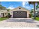 Two-car garage with dark brown door and paver driveway at 831 Evergreen St, New Smyrna Beach, FL 32169