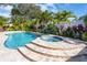 Freeform pool and spa with stone coping at 831 Evergreen St, New Smyrna Beach, FL 32169