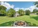 Large backyard with grassy area, fire pit, and deck with stairs at 12 Foster Dr, Daytona Beach, FL 32118