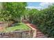 Landscaped backyard with brick pathway, lush greenery, and a grassy area at 12 Foster Dr, Daytona Beach, FL 32118