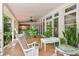 Relaxing covered porch with tiled floor, wicker furniture, and lush tropical plants at 12 Foster Dr, Daytona Beach, FL 32118