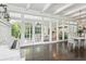 Bright dining room with hardwood floors, white piano, and French doors at 12 Foster Dr, Daytona Beach, FL 32118