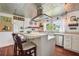 White kitchen with an island, stainless steel appliances, and wood floors at 12 Foster Dr, Daytona Beach, FL 32118