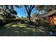 Spacious backyard with lush landscaping, a large tree, and a patio area at 1202 12Th St, Edgewater, FL 32132