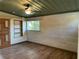 Unfurnished bedroom featuring light hardwood floors, wood accent wall and decorative ceiling at 1202 12Th St, Edgewater, FL 32132