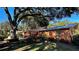 View of the home's exterior showcasing a large tree and yard at 1202 12Th St, Edgewater, FL 32132