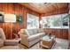 Cozy living room with wood paneled walls, comfortable seating, and large windows at 1207 Magnolia St, New Smyrna Beach, FL 32168