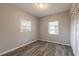 Bright bedroom with wood-look floors, two windows, and built-in closet at 1210 Washington St, New Smyrna Beach, FL 32168